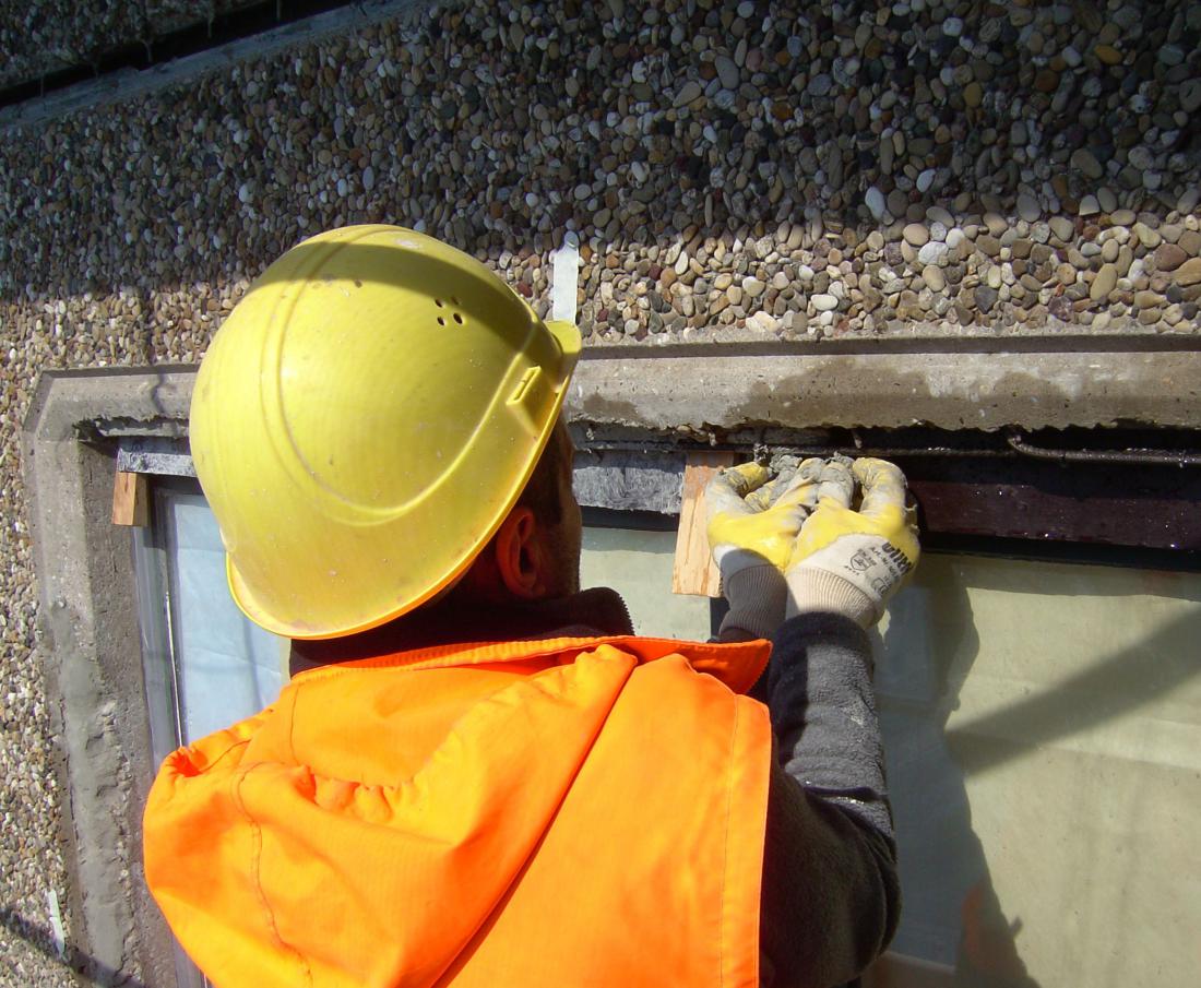 Fachkraft bei der Instandsetzung eines Betonbauteils an einer Fassade